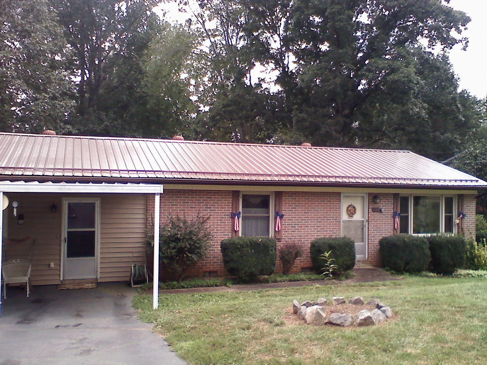 Bronze metal roof and carport on a brick ranch home — Roof Repair work by our crew in Barrington